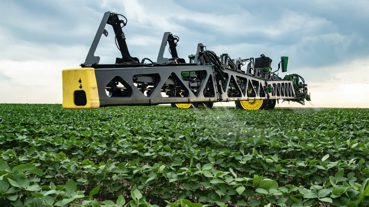 A tractor in a bean field with precision sprayer boom